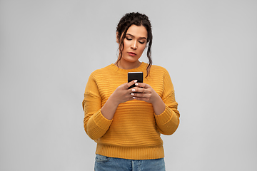 Image showing sad woman using smartphone