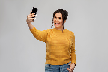 Image showing smiling young woman taking selfie by smartphone