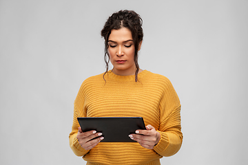 Image showing serious young woman using tablet pc computer