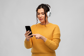 Image showing woman in headphones with smartphone