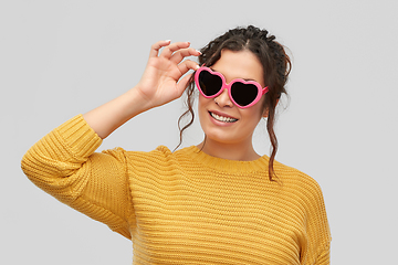 Image showing smiling young woman in heart-shaped sunglasses