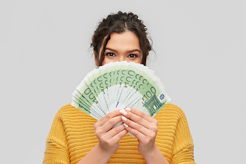 Image showing young woman covering her face with euro money