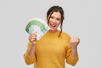 Image showing happy smiling young woman with euro money