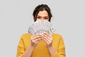 Image showing young woman covering her face with dollar money