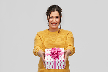 Image showing smiling young woman holding gift box