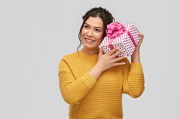 Image showing smiling young woman holding gift box