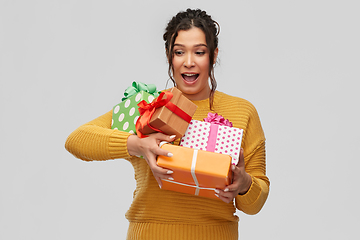 Image showing smiling young woman holding gift boxes
