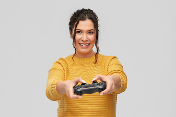 Image showing happy young woman with gamepad playing video game