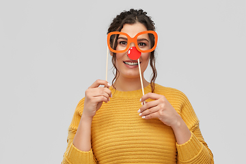 Image showing happy young woman with red clown nose and glasses