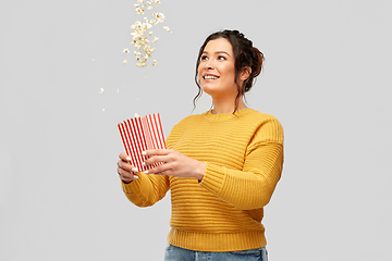 Image showing happy smiling young woman playing with popcorn