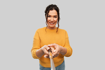 Image showing smiling woman taking picture with selfie stick