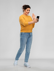 Image showing happy young woman having video call on smartphone