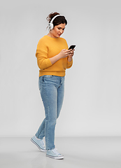 Image showing woman in headphones with smartphone