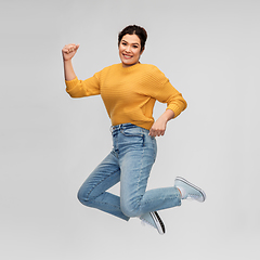 Image showing happy young woman with pierced nose jumping