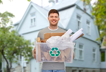 Image showing smiling young man sorting paper waste over house