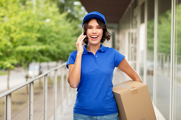 Image showing delivery girl with parcel box calls on smartphone