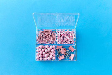 Image showing pins and clips in plastic pox on blue background