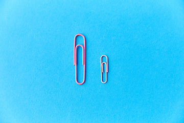 Image showing pink office clips on blue background