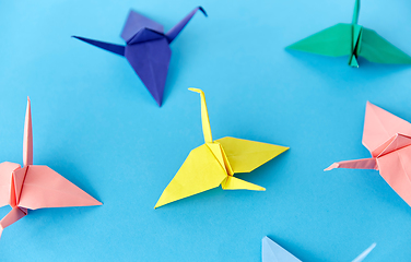 Image showing origami paper cranes on blue background