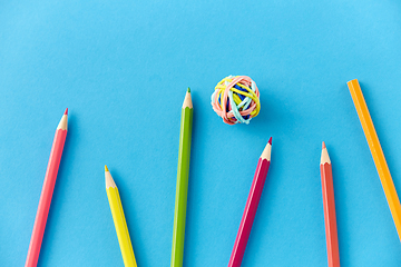 Image showing coloring pencils and rubber bands on blue