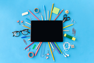 Image showing tablet pc and school supplies on blue background