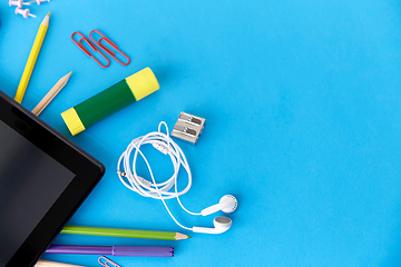 Image showing tablet pc and school supplies on blue background