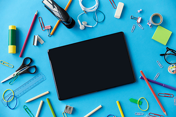 Image showing tablet pc and school supplies on blue background