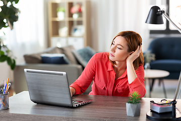 Image showing bored woman with laptop working at home office