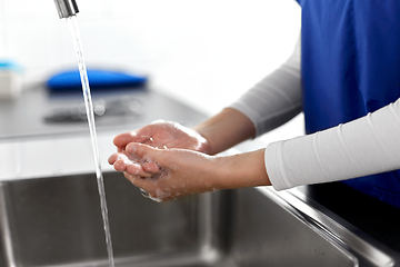 Image showing doctor or nurse washing hands with liquid soap