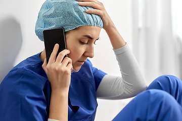 Image showing sad doctor or nurse calling on smartphone