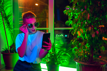 Image showing Cinematic portrait of handsome young woman in neon lighted interior