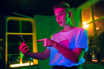 Image showing Cinematic portrait of handsome young woman in neon lighted interior