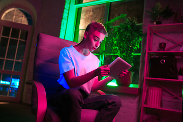 Image showing Cinematic portrait of handsome young woman in neon lighted interior