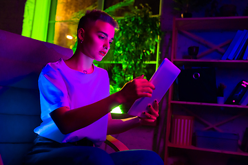 Image showing Cinematic portrait of handsome young woman in neon lighted interior