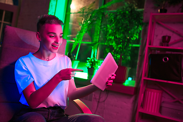 Image showing Cinematic portrait of handsome young woman in neon lighted interior