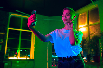 Image showing Cinematic portrait of handsome young woman in neon lighted interior