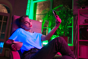 Image showing Cinematic portrait of handsome young woman in neon lighted interior