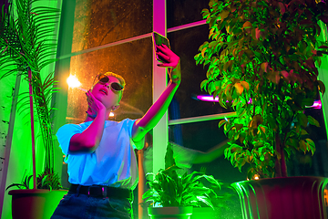 Image showing Cinematic portrait of handsome young woman in neon lighted interior