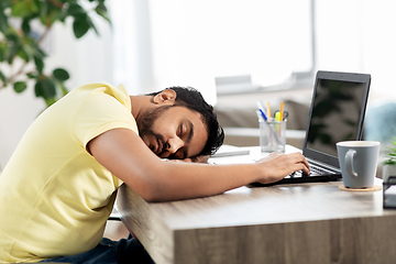 Image showing indian man sleeping on table with laptop at home