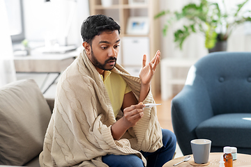 Image showing sick man measuring temperature by thermometer