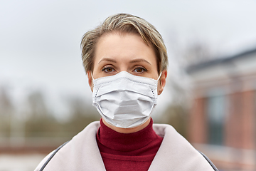 Image showing young woman wearing protective medical mask