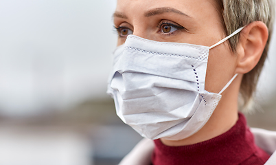 Image showing young woman wearing protective medical mask