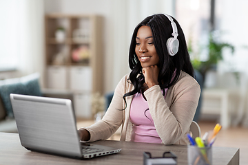 Image showing woman in headphones with laptop working at home