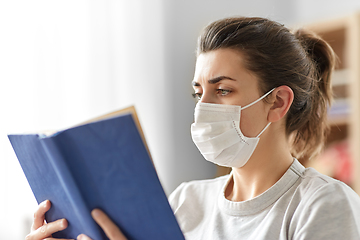 Image showing sick woman in medical mask reading book at home