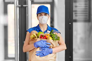 Image showing delivery woman in face mask with food in paper bag