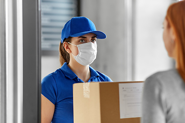 Image showing delivery girl in face mask giving parcel to woman