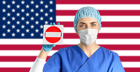 Image showing american doctor or nurse in mask with stop sign
