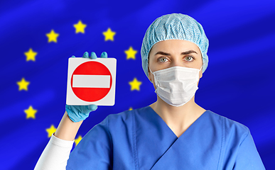 Image showing european doctor or nurse in mask showing stop sign