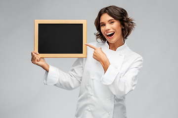 Image showing smiling female chef holding black chalkboard