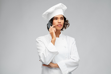 Image showing female chef in toque calling on smartphone